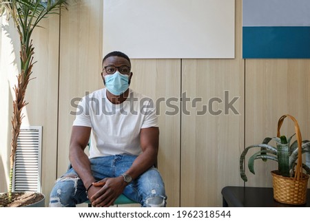 African male sitting on a chair while waiting to be attended by the nurse.