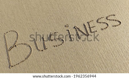 "Business" word is written on the beach sand