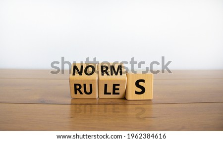 Rules or norms symbol. Turned cubes and changed the word 'norms' to 'rules'. Beautiful wooden table, white background, copy space. Business and rules or norms concept. Royalty-Free Stock Photo #1962384616