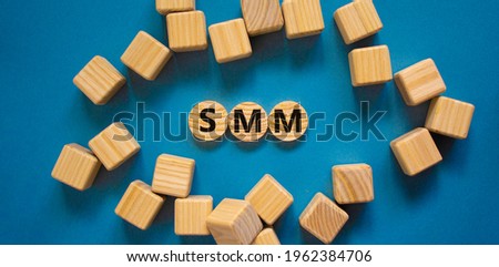SMM, social media marketing symbol. Wooden circles with word 'SMM - social media marketing' on beautiful blue background, copy space. Business, SMM - social media marketing concept.
