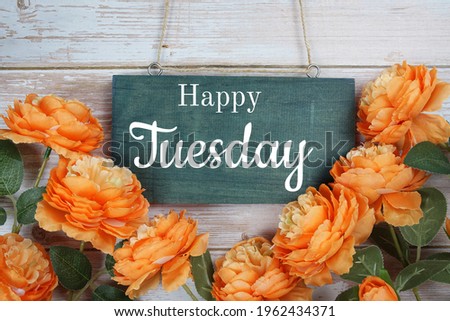 Happy Tuesday typography text with flower decoration on wooden background