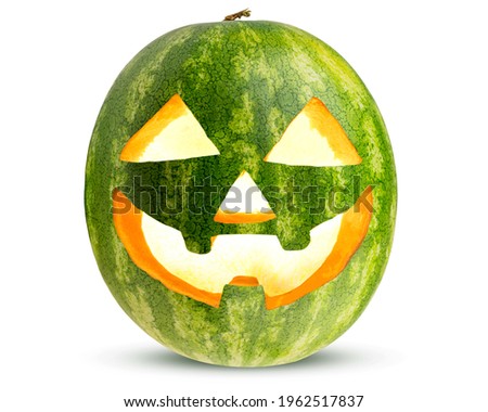 Halloween Carved Watermelon as Pumpkin. Jack O Lantern with burning candle inside. Scary decoration from pumpkins. Happy Halloween. White isolated background.