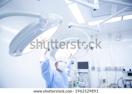 Nurse men put lamps on surgical tables