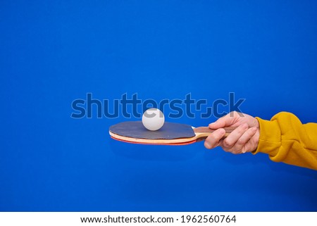 in hand a racket with a ball on a blue background