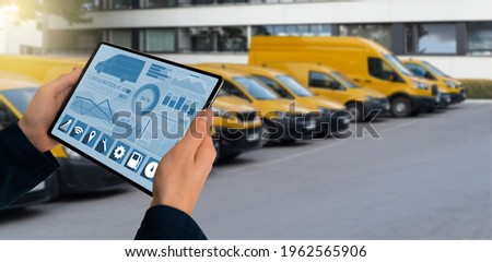 Manager with a digital tablet on the background of vans. Fleet management Royalty-Free Stock Photo #1962565906