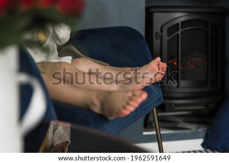 Picture of bare children's feet. Indoors. Room. Fireplace