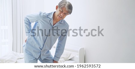 Middle aged asian man having back ache.