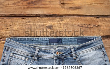 Blue jeans on a wooden background, texture of denim. Top view. 