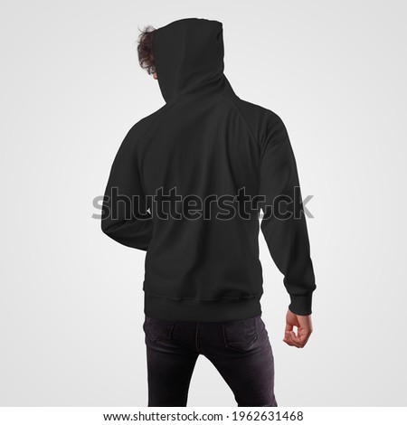 Mockup of a black men's hoodie on a guy in a hood, back view, for presentation of design, pattern. Apparel for advertising in an online store, print. Casual sweatshirt template isolated on background