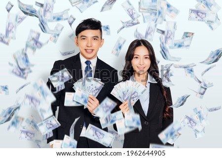 young business man and woman showing the money under the money rain