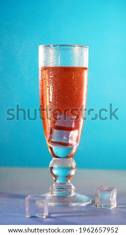 A glass of iced red wine, blue background