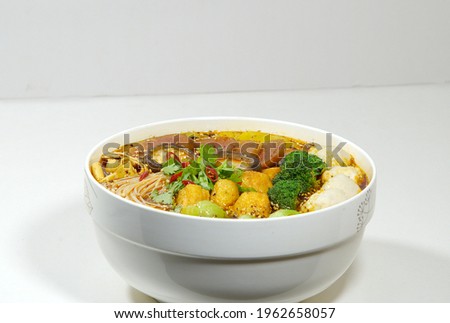 Hot pot is also called Mala Tang. Enoki mushroom, tofu bubble, meatball, mushroom, vegetable ball, white background