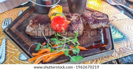 Namibian braai, Kudu, Springbok, Zebra steak with salad at a Restaurant in Windhoek, close up with selected focus