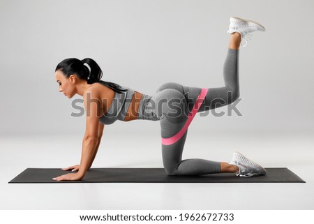 Athletic girl doing kickback exercise for glutes with resistance band. Fitness woman working out donkey kicks
 Royalty-Free Stock Photo #1962672733