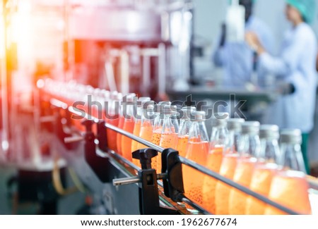 Drink factory production line fruit juice beverage product at conveyor belt. Royalty-Free Stock Photo #1962677674