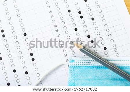 testing in exercise and examination work. computer worksheet with pencil in school test room, lead pencil and medical mask. the concept of education during a pandemic
