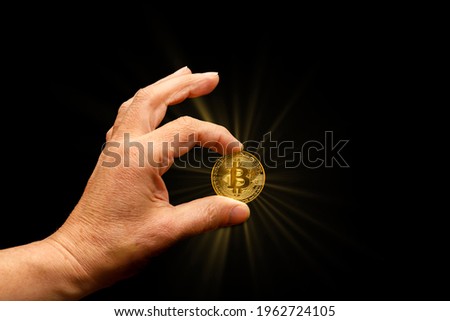 Human hand holds bitcoin coin with sun star
