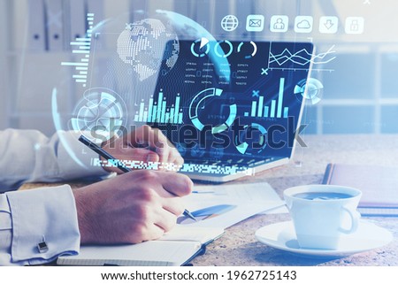 Office man hand with pen and business papers, laptop on the table. Stock market changes, business bar chart. Double exposure of lines, pie chart and graphs. Concept of financial analysis