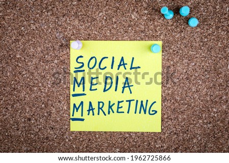 Social Media Marketing. Text on a sticky note pinned to a corkboard.