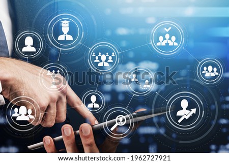 Side view of businessman hand in formal suit using tablet device, working on new project. Double exposure. Concept of success. Social media icon huds and recruitment process.