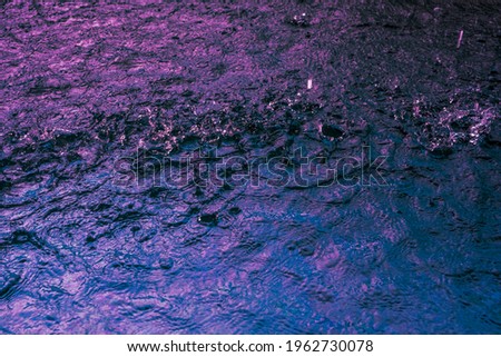 Rain fall on the pool in rains season. Close up of violet water waves, low angle view. Selective focus. Background texture. High quality photo