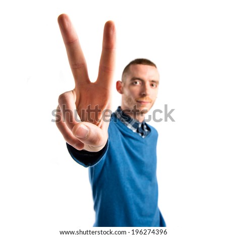 Man making victory gesture over isolated white background 