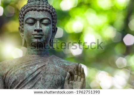 Buddha face, The Buddha statue is made of gold, bronze. On natural bokeh background Royalty-Free Stock Photo #1962751390