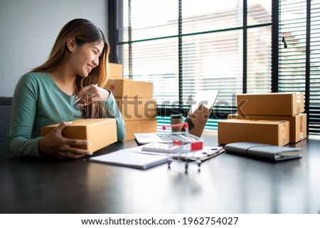 Small business entrepreneur SME freelance,Portrait of young asian woman working at home office,online marketing packaging delivery box,e-commerce business concept.