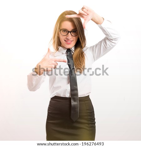 Pretty businesswoman focusing with her fingers on a white background 