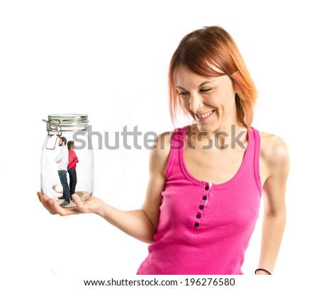 Evil girl enclosing a couple in a jar glass over white background