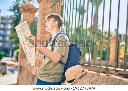 Young caucasian tourist man smiling happy holding map at the city.
