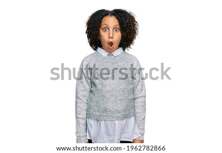 Young little girl with afro hair wearing casual clothes afraid and shocked with surprise expression, fear and excited face. 