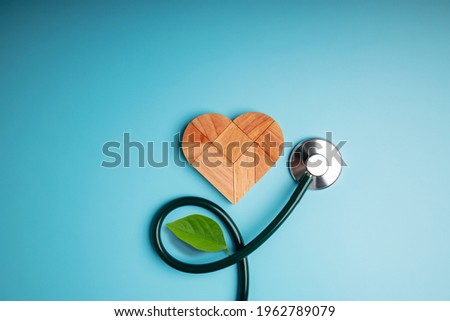 Health Care, Harmony and Organic Healthy Lifestyle Concept. Living and Close to Nature. Wooden Jigsaw as Heart Shape with Stethoscope and Leaf. Look like Flower Plant. Growth of Love and Relationship Royalty-Free Stock Photo #1962789079