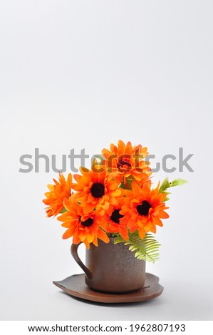 Coffee mug or tea mug with orange flowers on top.Minimal style, romantic mood.