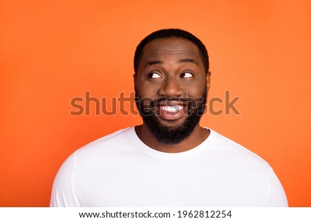 Photo of charming dreamy happy young afro american man look empty space good mood positive isolated on orange color background