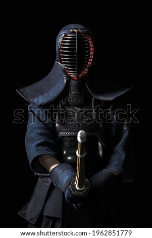 Japanese kendo fighter with with shinai on a black background Royalty-Free Stock Photo #1962851779
