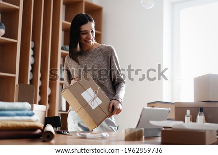 Indian mixed-race female seller using tablet checking ecommerce clothing store orders Royalty-Free Stock Photo #1962859786