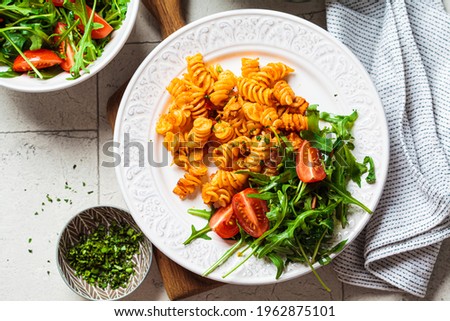 Baked pasta with chicken and cheese in white plate, gray background. Italian cuisine concept.