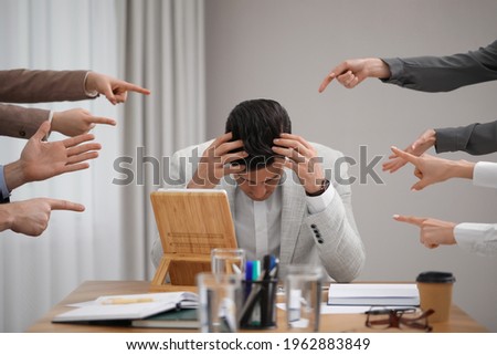 Coworkers bullying their colleague at workplace in office, closeup Royalty-Free Stock Photo #1962883849