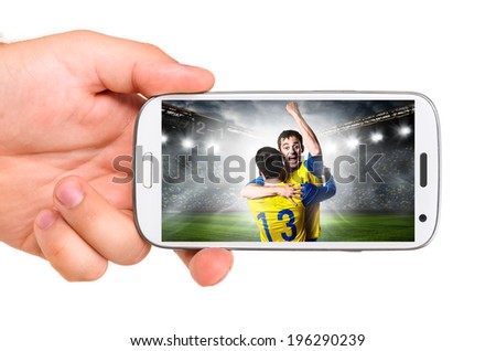 hand is holding a modern phone with soccer or football player on screen