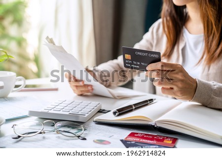 Stressed young woman calculating monthly home expenses, taxes, bank account balance and credit card bills payment, Income is not enough for expenses Royalty-Free Stock Photo #1962914824