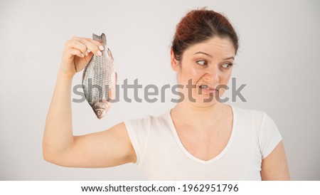 Caucasian woman opposes the disgusting smell of fish. A metaphor for women's health and intimate hygiene. Royalty-Free Stock Photo #1962951796