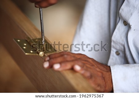 Royalty free photo of carpenter fixing hinge in Hinge Recesses (Mortises) in Wooden door Frame

