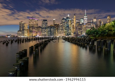 Beautiful Night Light and Lower Manhattan skyline with East River and New York City. Twilight with Reflections and Abandoned Pier at Sunset from Brooklyn Bridge Park