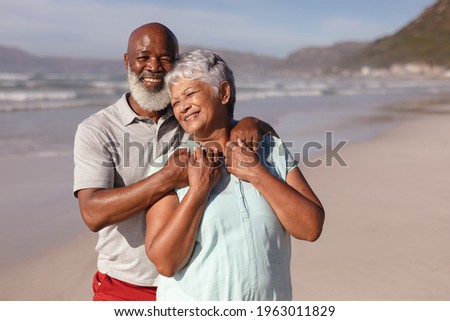 Happy senior african american couple embracing each other on the beach. travel vacation retirement lifestyle concept