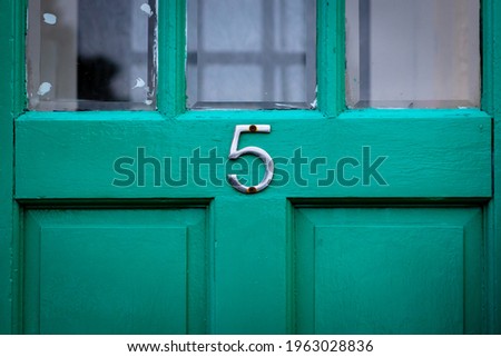 House number 5 on a green wooden front door