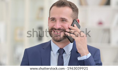 Portrait of Cheerful Businessman Talking on Phone