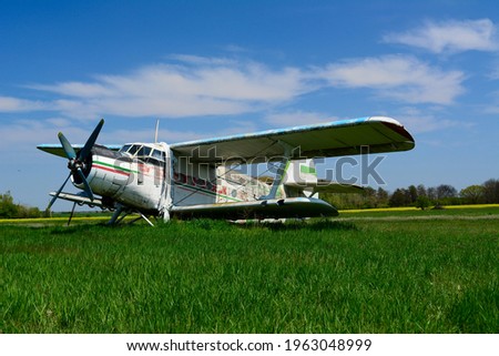 Decommissioned single-engine biplane utility-agricultural aircraf on a green field. Pictured April 2021. 