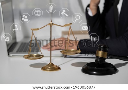 Lawyer man using digital tablet and laptop computer with law virtual interface icons screen at table office, Law business internet technology concept, blurred background. 