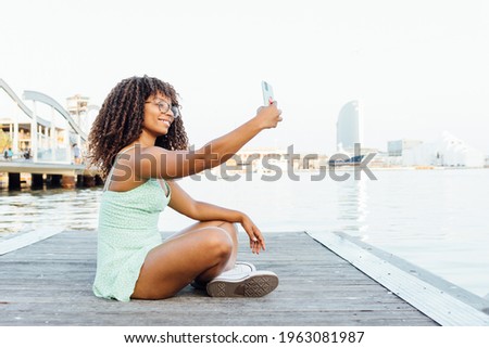 african woman takes a selfie by the sea
